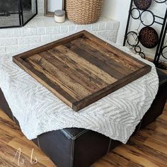 a wooden tray sitting on top of a ottoman