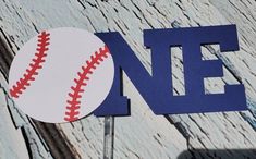 a close up of a baseball on top of a wooden sign with the word one painted on it