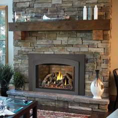 a living room with a fire place in the center and a vase on the table