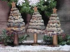 three christmas trees made out of burlocks with snow on them and pine cones