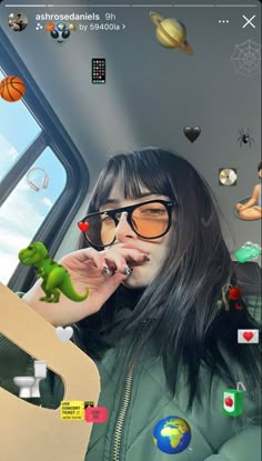 a woman with glasses and a green jacket is holding a toy dinosaur in front of her face