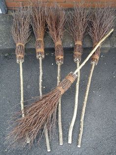 four brooms are lined up on the sidewalk