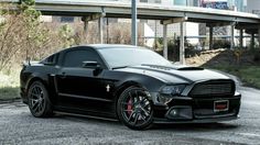 a black mustang parked in front of a building