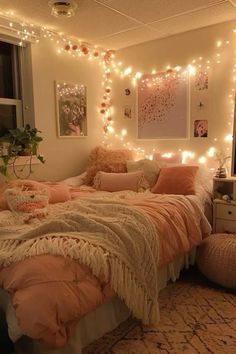 a bedroom with lights on the wall and a bed covered in pink sheets, pillows and blankets