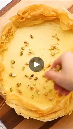 a person placing pistachio on top of a pie