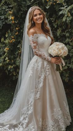 a woman in a wedding dress holding a bouquet and smiling at the camera while wearing a veil