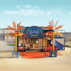 a small store with palm trees on the front