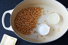 some food is being cooked in a pan on the table with milk and butter for dipping