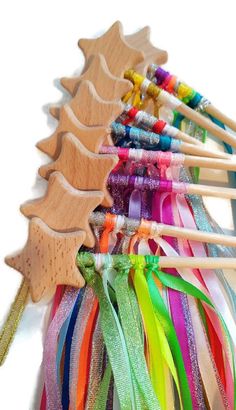 a row of wooden skewers with different colored ribbons attached to them on a white background