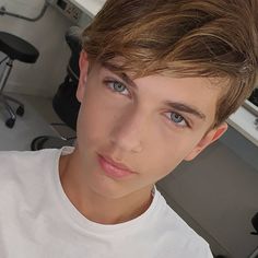 a young man is taking a selfie in front of a computer desk and chair