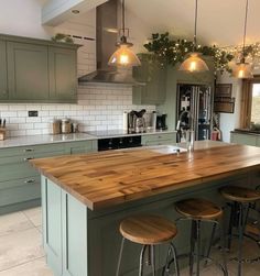 a kitchen island with three stools next to it