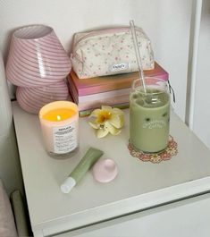 an assortment of items on a table including candles, makeup and other personal care items