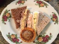 a plate with three sandwiches on it and a dipping sauce in the middle, sitting on a granite countertop