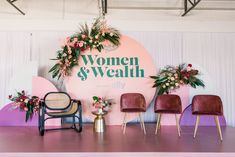 several chairs and tables in front of a sign that says women & wealth on it