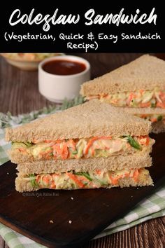 two sandwiches cut in half sitting on top of a cutting board next to a cup of sauce