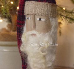 an old fashioned santa clause doll is sitting on a table next to a christmas tree