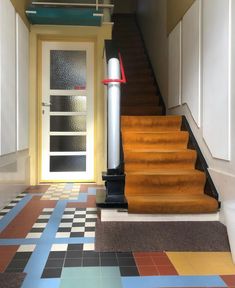 the stairs are painted with different colors and patterns, along with a door to another room