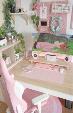 a desk with a pink chair and computer monitor on it, in front of a plant