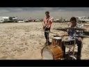 two people playing drums on the beach