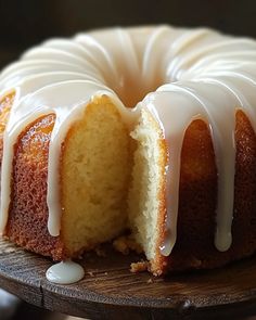 a bundt cake with white icing on a wooden platter, ready to be eaten