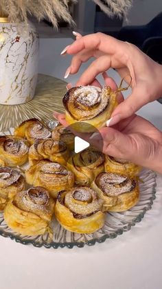 two hands reaching for pastries on a platter with gold decorations and feathers in the background