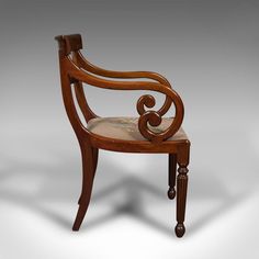 a wooden chair with an intricately carved back and arm rests on a white background