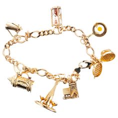 Figaro style 14k yellow gold charm bracelet. Food and drink motif charm bracelet consists of seven charms. A waffle iron, frying pan with egg, sand timer, carafe stein, champagne bottle and glasses and a tavern all in 14k yellow gold. 7.75 inches long. 14k yellow gold Stamped: 14k 24.7 grams Bracelet: 7.75 Inches Cheap Gold Charm Bracelets, Luxury Gold Round Charm Bracelet, Luxury Vintage Charm Bracelet, Cheap Yellow Charm Bracelet For Gift, Luxury Yellow Gold Fine Jewelry Charm Bracelet, Gold Charm Bracelet Gift, Sand Timer, Sand Timers, Jewelry Words