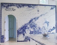 a blue and white tiled wall with a bowl on the counter in front of it