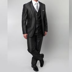 Presenting The Tazio Dark Charcoal Men's 3pc Suit With Peak Lapel And Pick Stitch Finisha Pinnacle Of Sartorial Excellence. Imbued With Meticulous Craftsmanship, This Suit Boasts A Solid Color, A 1-Button Front Closure, And A Slim-Fit Silhouette For A Contemporary Yet Timeless Appeal. The Peak Lapel, Side Vents, And Underarm Sweat Guards Enhance Comfort And Sophistication. The Vest Features A V-Neck Finish And 5-Button Closure, While The Flat-Front Pants With A Pick Stitch Finish, Two Back Besom Fitted Gray Semi-formal Set, Fitted Gray Business Sets, Elegant Fitted Gray Sets, Tailored Gray Formal Sets, Tailored Gray Sets For Formal Occasions, Gray Fitted Party Sets, Elegant Semi-formal Gray Sets, Gray Fitted Suit For Groom, Outfit 2023