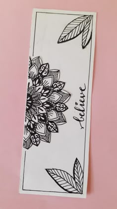 a card with some black and white flowers on the front, and leaves on the back