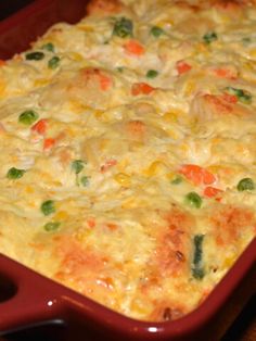 a casserole dish with vegetables and meat in it on a wooden table top