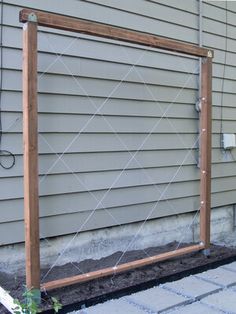 a wooden frame sitting on the side of a house