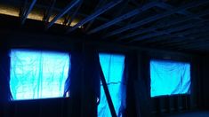 an unfinished room with blue light coming through the windows