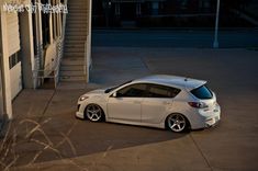 a white car parked in front of a building