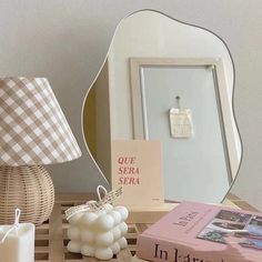 a table topped with a mirror and a lamp next to a box filled with candles