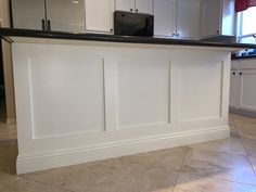 a kitchen with white cabinets and black counter tops