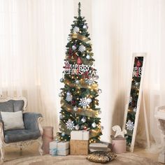 a decorated christmas tree in a living room next to a mirror and chair with presents under it