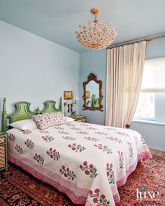 a bedroom with a chandelier hanging from the ceiling and a bed in front of a window