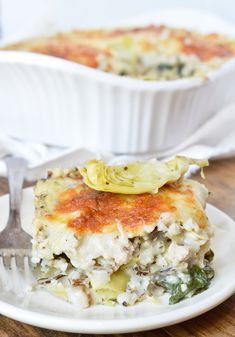 a white plate topped with a casserole covered in cheese and veggies