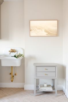 a white sink sitting next to a wall mounted faucet