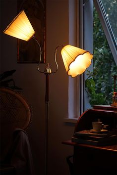 two floor lamps sitting next to a window