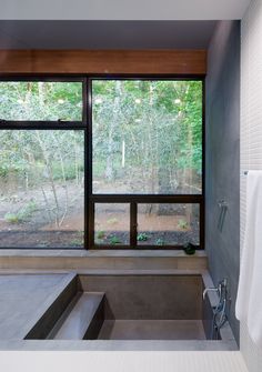 a bathroom with a large window overlooking the woods