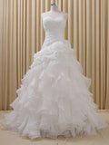 a wedding dress is displayed on a mannequin in front of a curtained wall