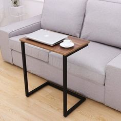 a table with a laptop on it next to a couch