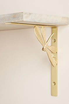 a wall mounted shelf with a dragonfly on it