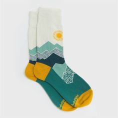 Peak Experience Organic Cotton Socks by Happy Earth It's all about the climb in these mountain-themed socks. Teals, beiges, and blues make up this scene, highlighted by a golden sun, heel, and toe. Soft, supportive socks made to put your best foot forward! Knit from comfy, breathable organic cotton with a touch of recycled nylon and elastane to enhance flexibility and moisture-wicking performance. Soft, breathable organic cotton Cushioned foot and arch support Reinforced toe and heel "Happy Eart Sun Moon Lake, Golden Sun, Happy Earth, Cotton Socks, New Print, Socks For Sale, Arch Support, Moisture Wicking, Arch