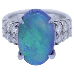 A fine and natural opal from Australia. It weighs 5.91 carats and has excellent play of color. As you turn the stone large flashes of green and blue will appear and completely cover the stone. It is accented by 0.92 carats of round brilliant cut diamonds. Hand-fabricated in a platinum mounting. Ring Size 5.75 Black Pearl Ring, Vintage Opal Engagement Ring, Australian Black Opal, Sweet Ring, Tahitian Black Pearls, Platinum Diamond Rings, Engagement Rings Opal, Geometric Ring, Platinum Ring