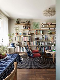 a living room filled with furniture and bookshelves next to a table covered in fruit