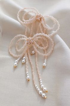 the beaded bracelets are on top of a white cloth with gold beads and pearls