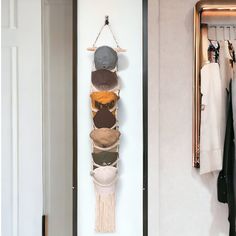 there is a rack with hats hanging on the wall next to a coat hanger